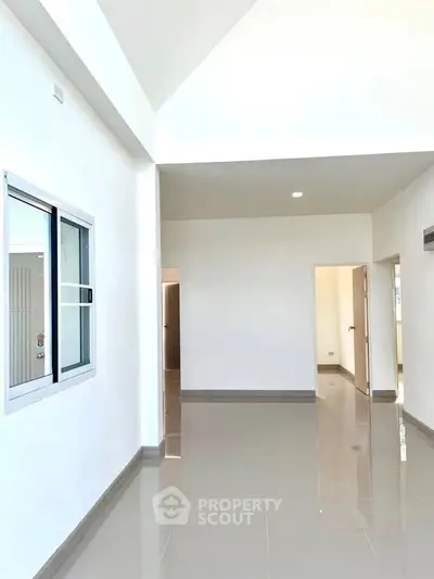 Spacious modern interior with high ceilings and glossy tiled floors.