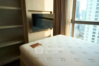 Modern bedroom with large window and wall-mounted TV in urban apartment