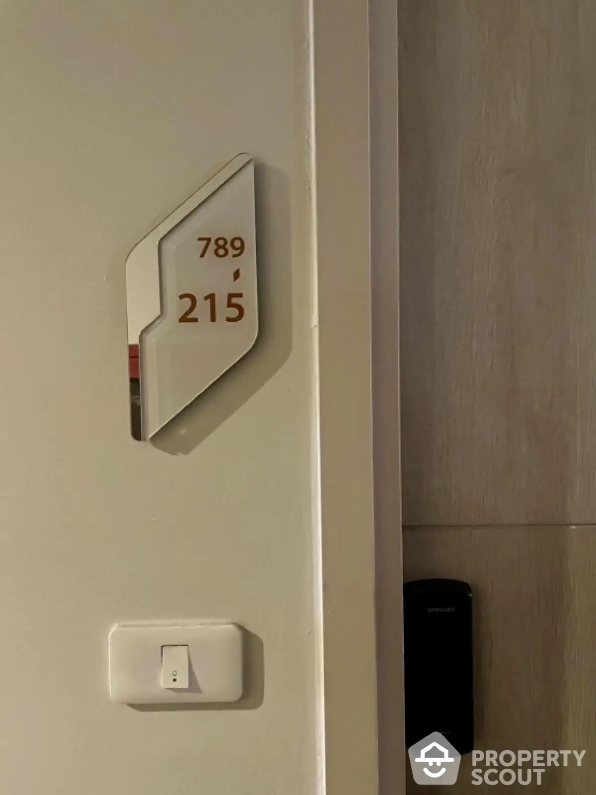 Modern apartment entrance with electronic lock and room number signage