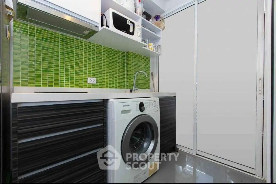 Modern kitchen with washing machine and vibrant green backsplash