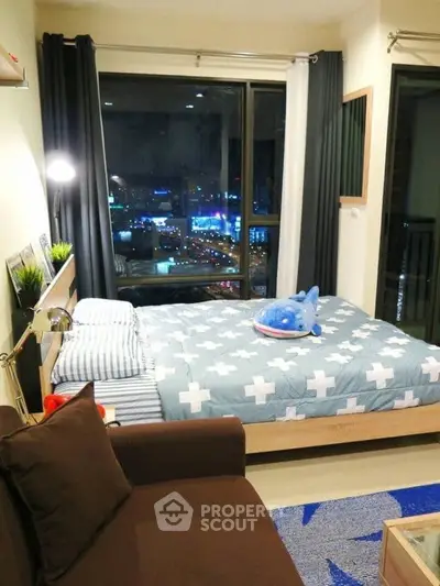 Cozy bedroom with city view, featuring modern decor and comfortable furnishings, ideal for urban living.