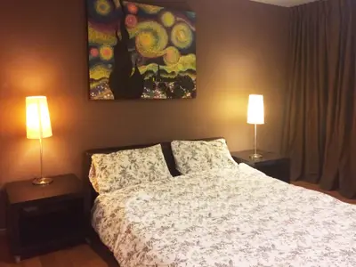 Cozy bedroom with stylish decor and warm lighting, perfect for relaxation.