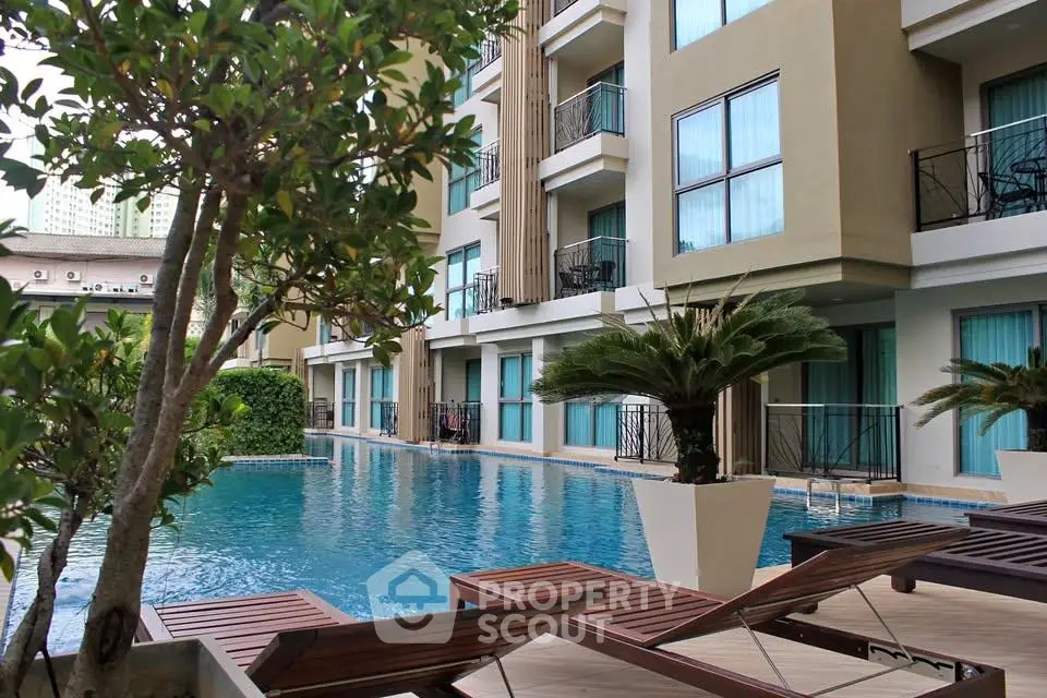 Luxurious apartment complex with a stunning poolside view and modern architecture.