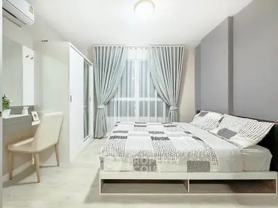Modern bedroom with stylish decor, featuring a comfortable bed, sleek wardrobe, and elegant curtains.