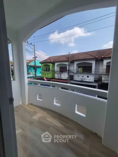 Charming balcony with tiled flooring and neighborhood view, perfect for relaxation and enjoying the outdoors.