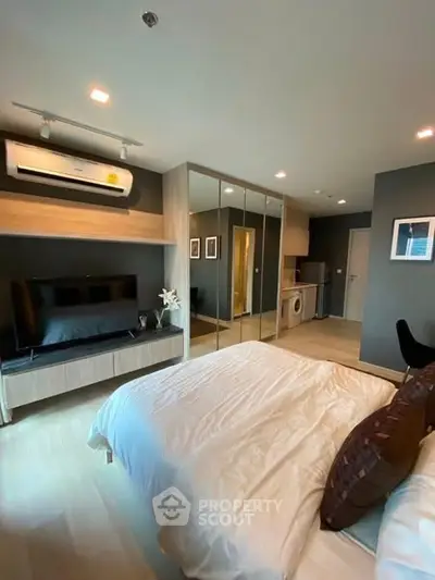 Modern bedroom with mirrored wardrobe and in-room washing machine