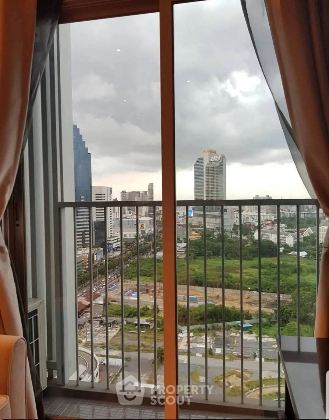 Stunning city view from a high-rise balcony with modern urban skyline.
