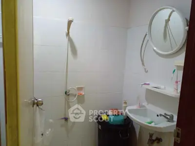 Compact bathroom with shower and sink, ideal for small apartments.
