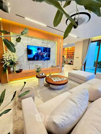 Luxurious living room with modern decor, large TV, and elegant lighting