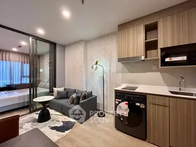 Modern studio apartment with open layout, featuring cozy living area and compact kitchen.