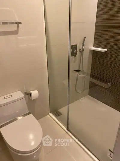 Modern bathroom with glass shower and sleek fixtures in a contemporary home.