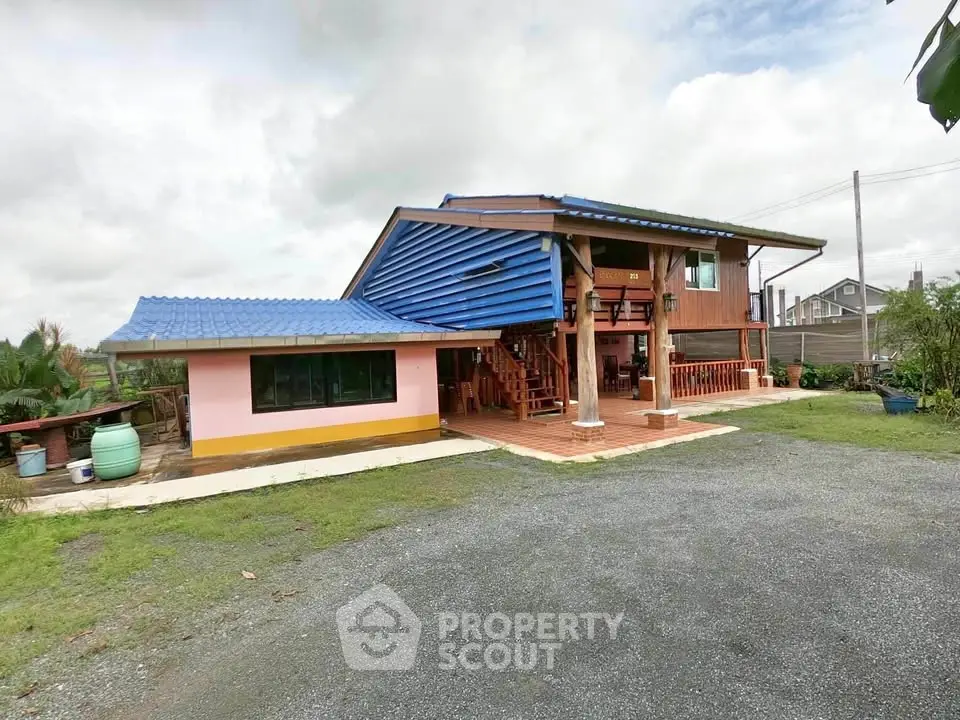 Charming two-story house with blue roof and spacious outdoor area
