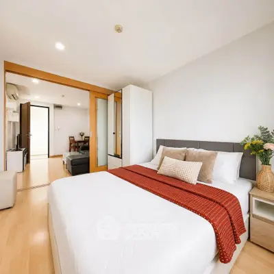 Spacious modern bedroom with cozy decor and sliding doors leading to living area.