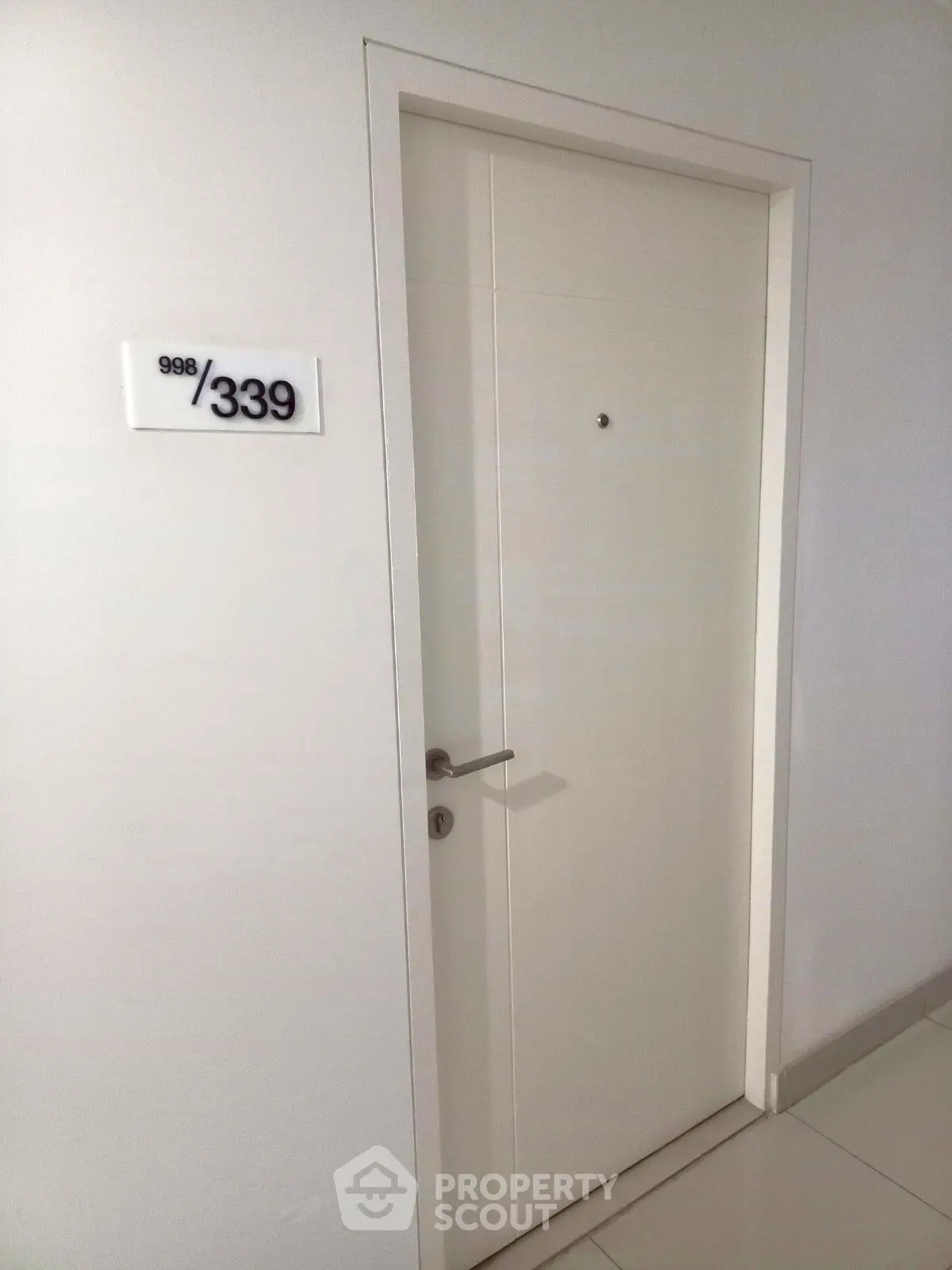 Modern apartment entrance with sleek white door and room number 339, showcasing minimalist design.