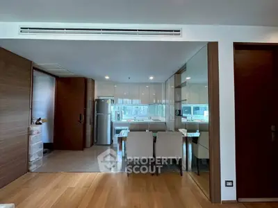 Modern open-layout kitchen with dining area and sleek appliances in a stylish apartment.