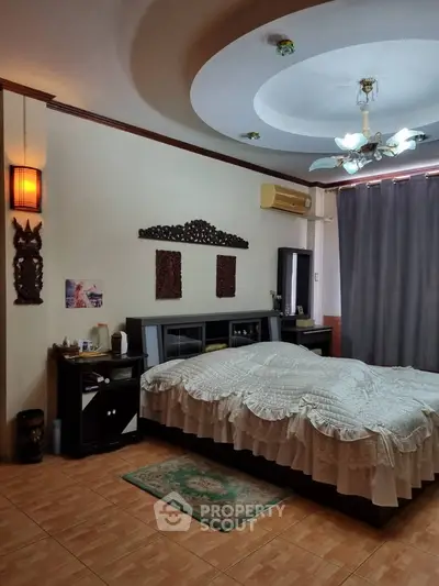 Spacious bedroom with elegant ceiling design and cozy decor