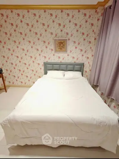 Charming bedroom with floral wallpaper and cozy bed in a stylish home.