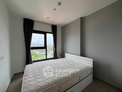 Modern bedroom with large window offering city view, featuring a comfortable bed and minimalist decor.
