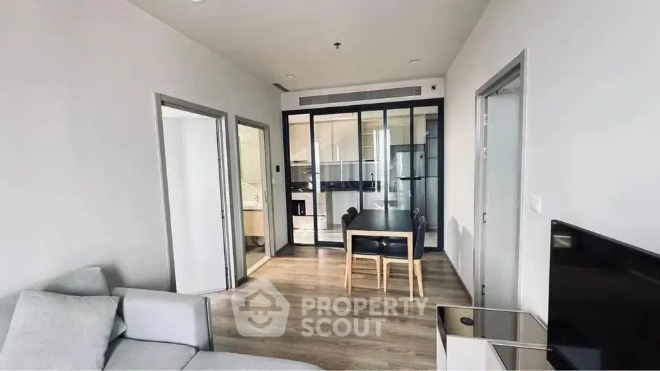 Modern living room with sleek furniture and open kitchen layout in a stylish apartment.