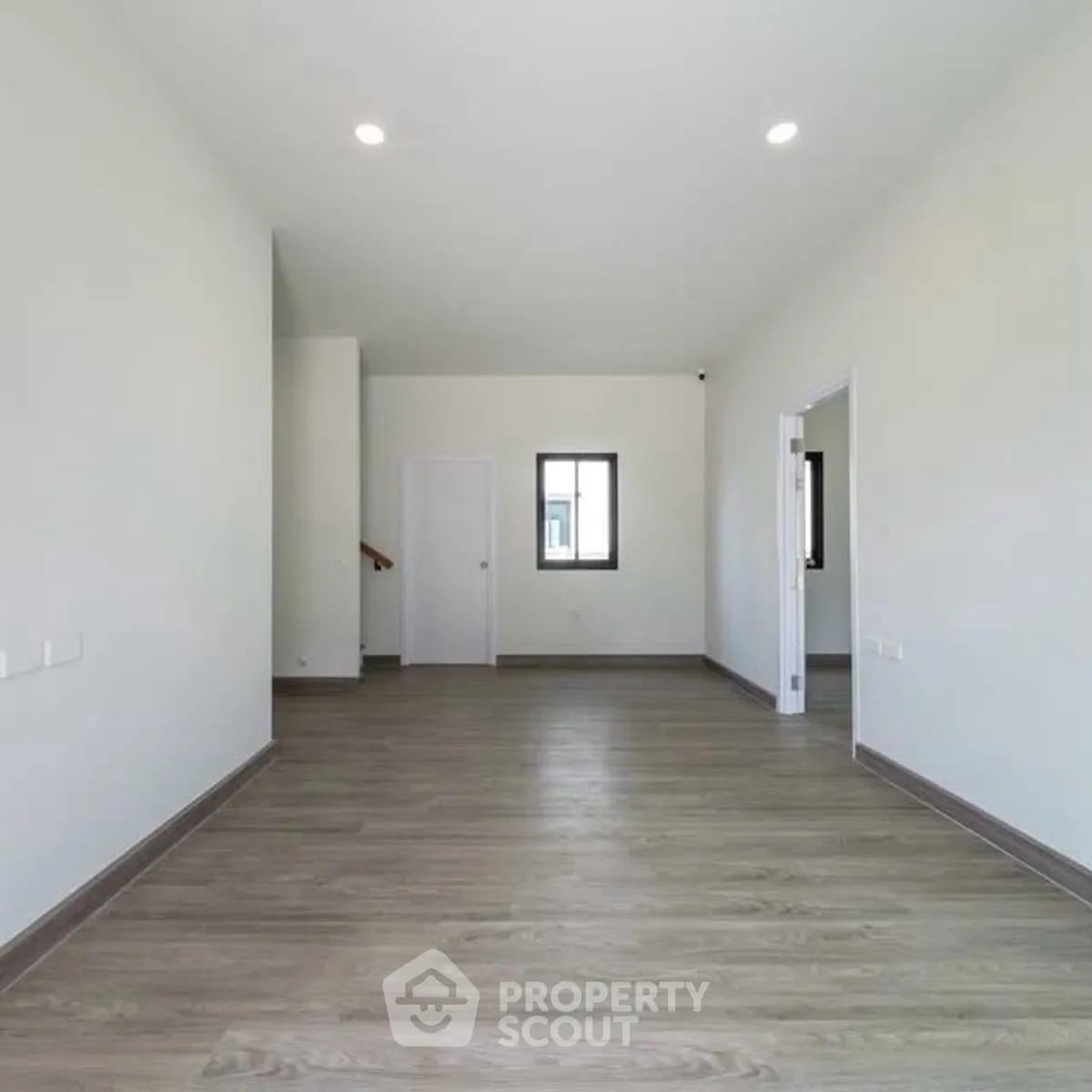 Spacious empty room with modern flooring and bright lighting, perfect for customization.