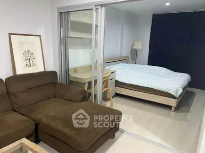 Modern studio apartment with cozy living area and comfortable bed