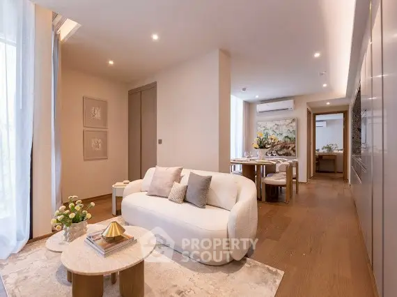 Luxurious modern living room with elegant decor and open dining area, featuring stylish furniture and warm lighting.
