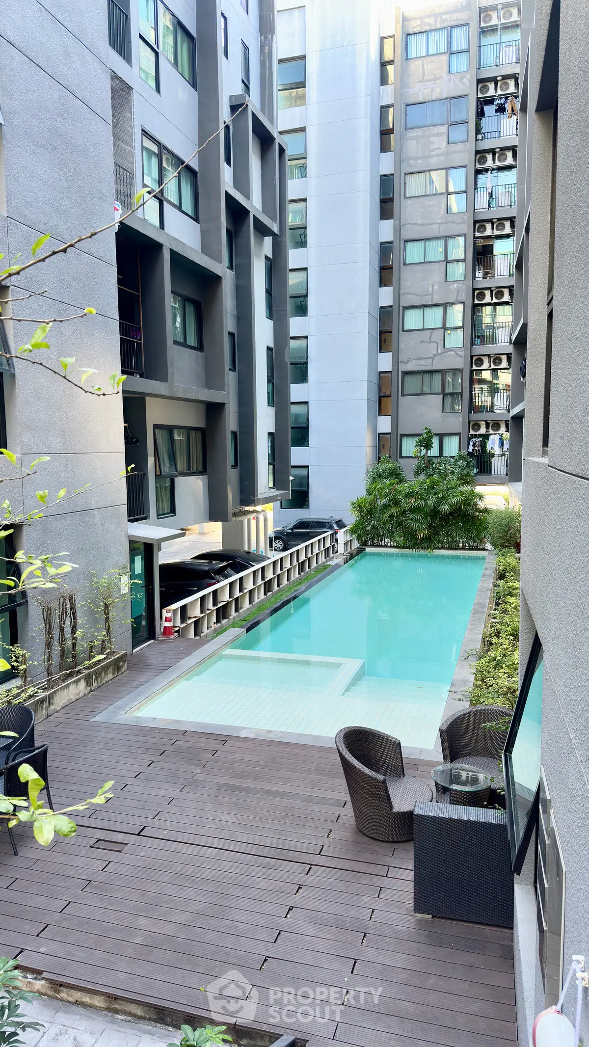 Modern apartment complex with inviting pool and stylish outdoor seating area.