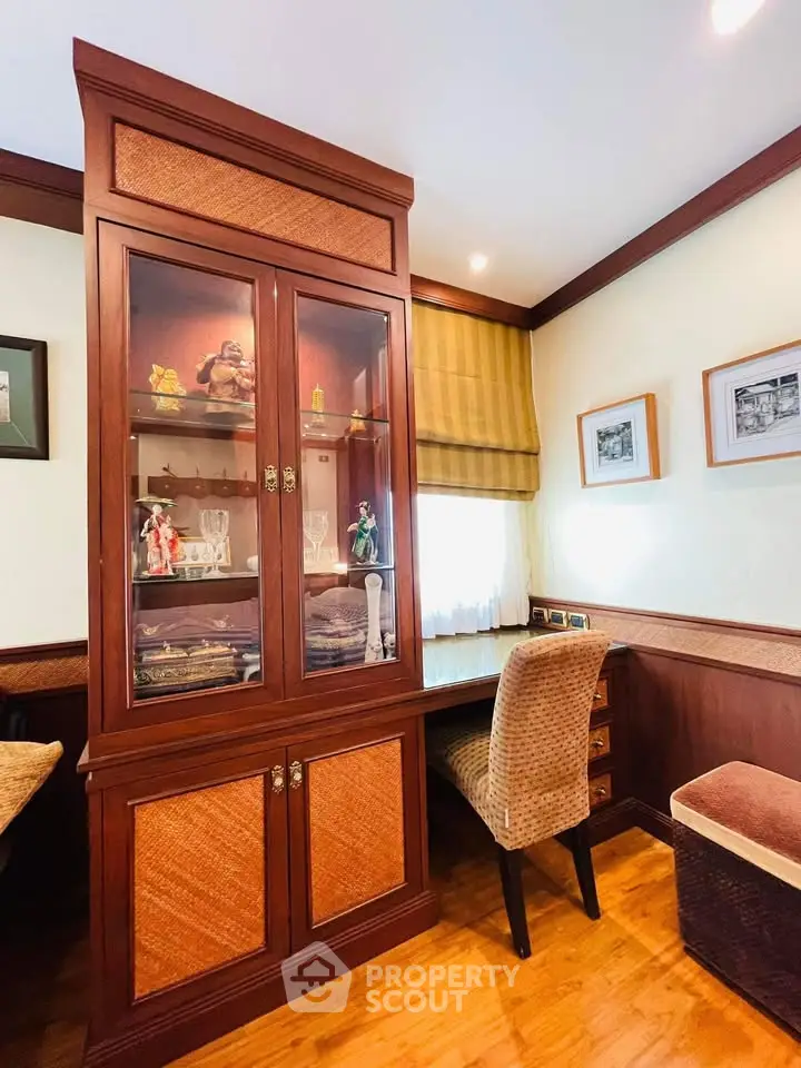 Charming study room with elegant wooden cabinet and cozy seating, perfect for a home office setup.