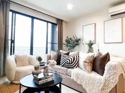 Stylish living room with cozy sofa, chic decor, and large window offering natural light.