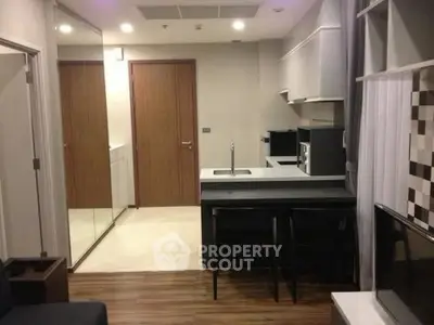 Modern compact kitchen with sleek design and integrated appliances in a cozy apartment.