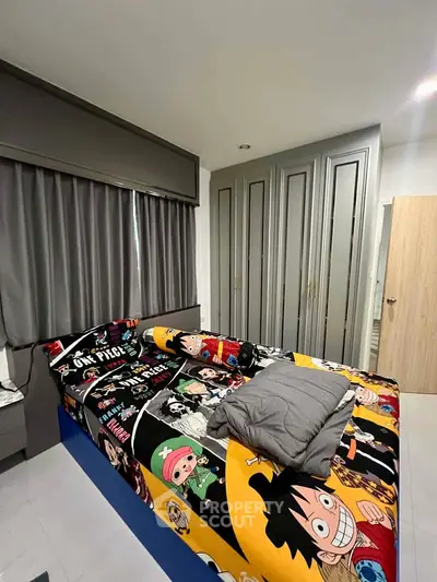 Modern bedroom with stylish closet and anime-themed bedding in a cozy apartment.