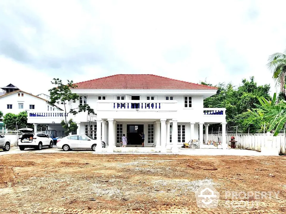 Stunning two-story white house with red roof and spacious front yard