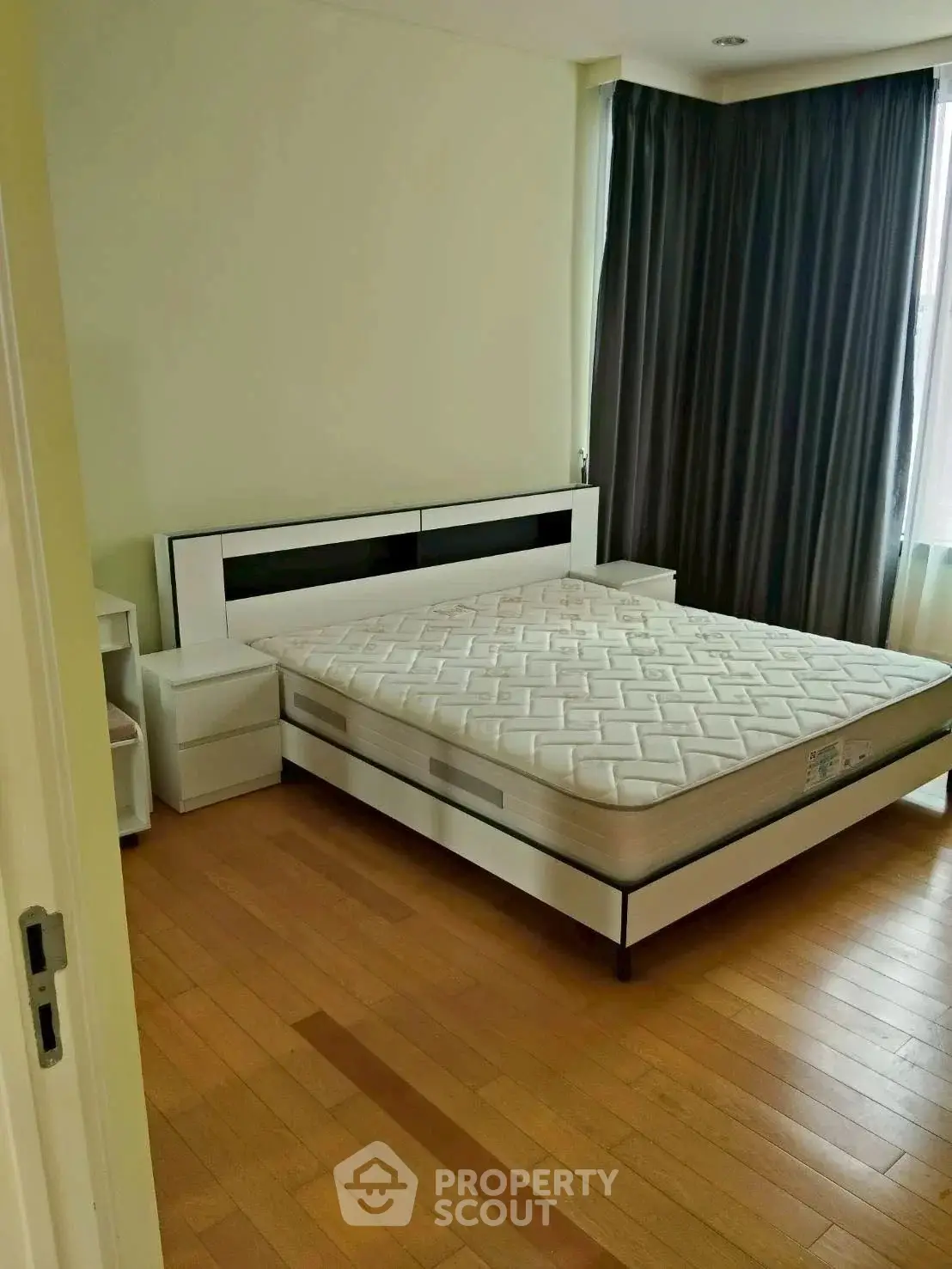 Spacious bedroom with modern design and large window for natural light.