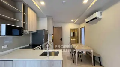Modern kitchen with dining area featuring sleek cabinetry and built-in appliances.