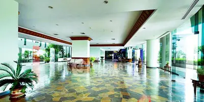 Spacious and elegant building entrance with modern design and lush greenery.