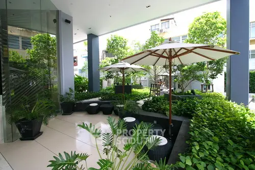 Luxurious garden area with stylish seating and umbrellas in modern real estate property.