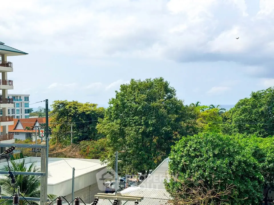 Scenic view from a balcony overlooking lush greenery and distant buildings