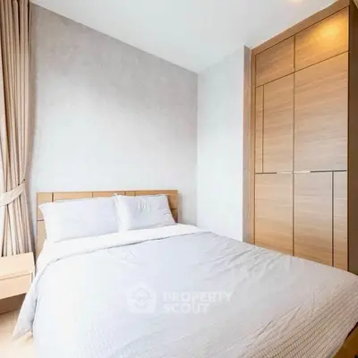 Modern bedroom with cozy bed and built-in wooden wardrobe