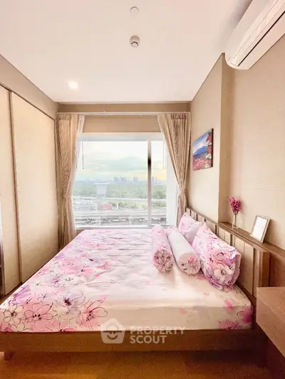 Cozy bedroom with city view, featuring floral bedding and modern decor.