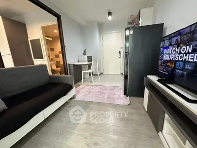 Modern living room with sleek furniture and open layout, featuring a cozy sofa and flat-screen TV.