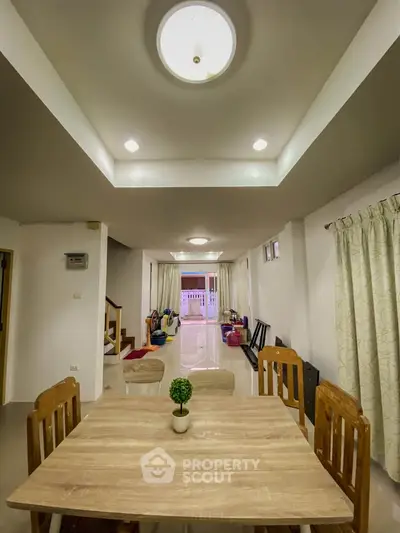 Spacious dining area with modern lighting and open layout in a cozy home.