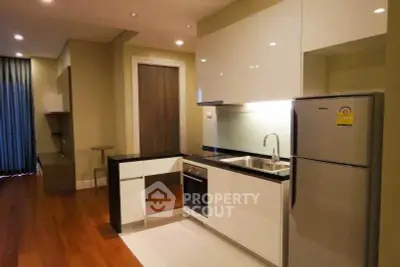 Modern kitchen with sleek cabinetry and stainless steel appliances in a stylish apartment.