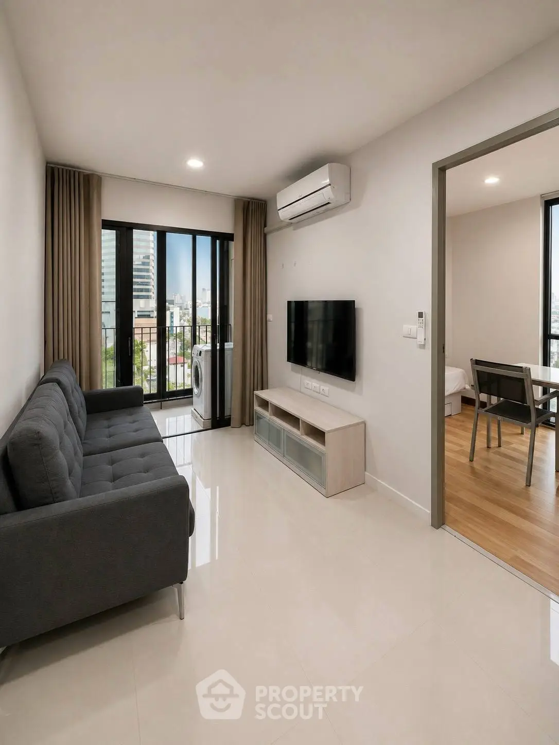 Modern living room with sleek furniture and city view balcony in a stylish apartment.