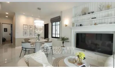 Elegant living room with modern decor, large TV, and stylish dining area in open layout.
