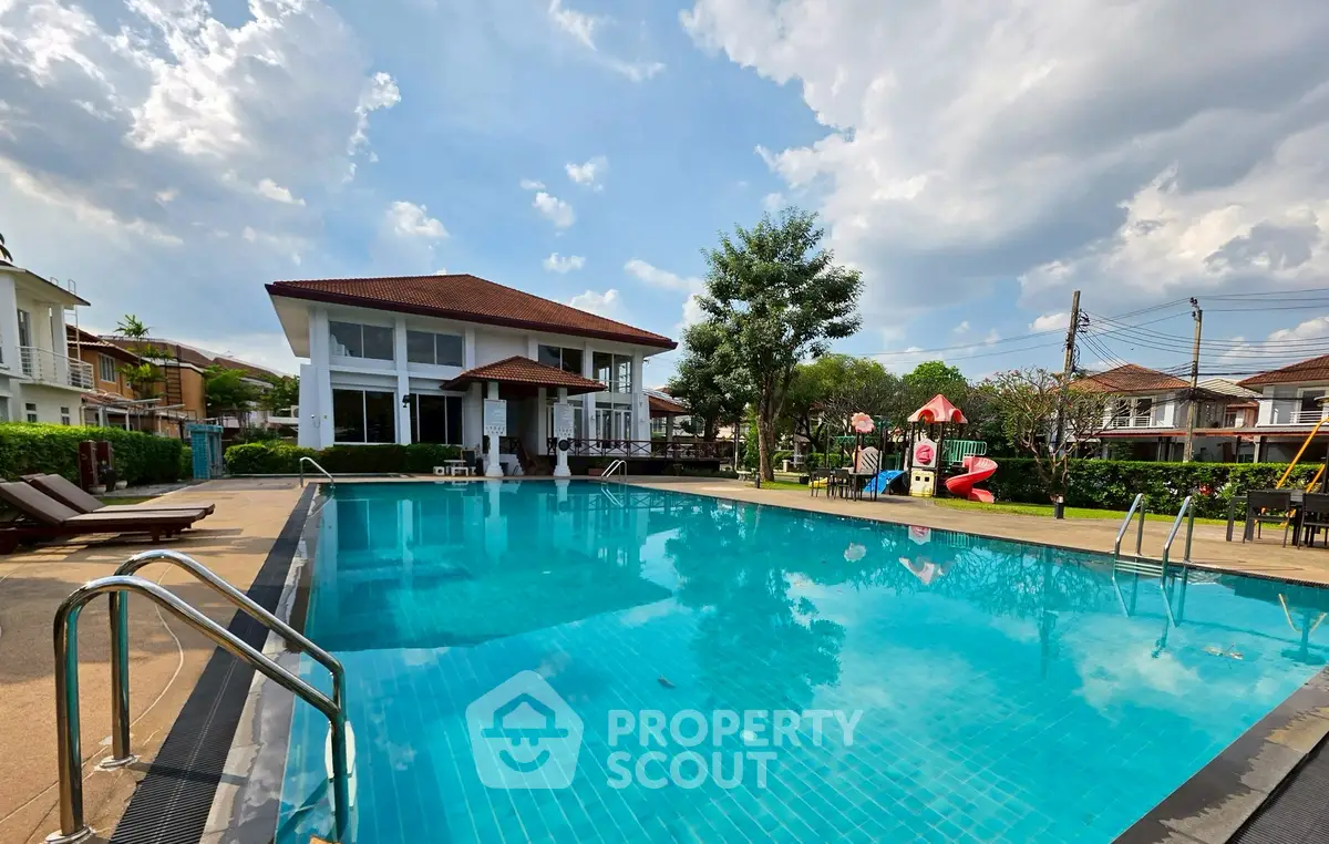 Luxurious residential pool area with modern clubhouse and lush greenery, perfect for relaxation and leisure.