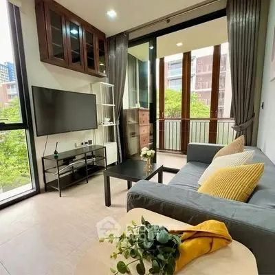 Modern living room with balcony view, stylish decor, and natural light.