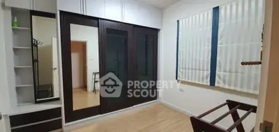 Spacious bedroom with mirrored wardrobe and modern decor