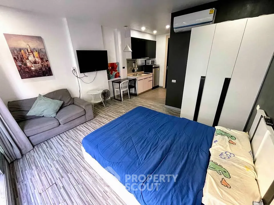 Modern studio apartment with cozy living area and compact kitchen, featuring stylish decor and ample natural light.