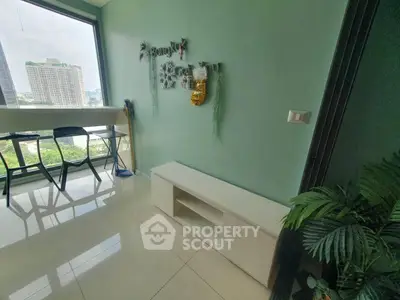 Modern apartment with city view and stylish decor, featuring a cozy seating area and lush greenery.