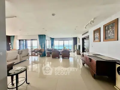 Spacious living room with ocean view, elegant decor, and abundant natural light.
